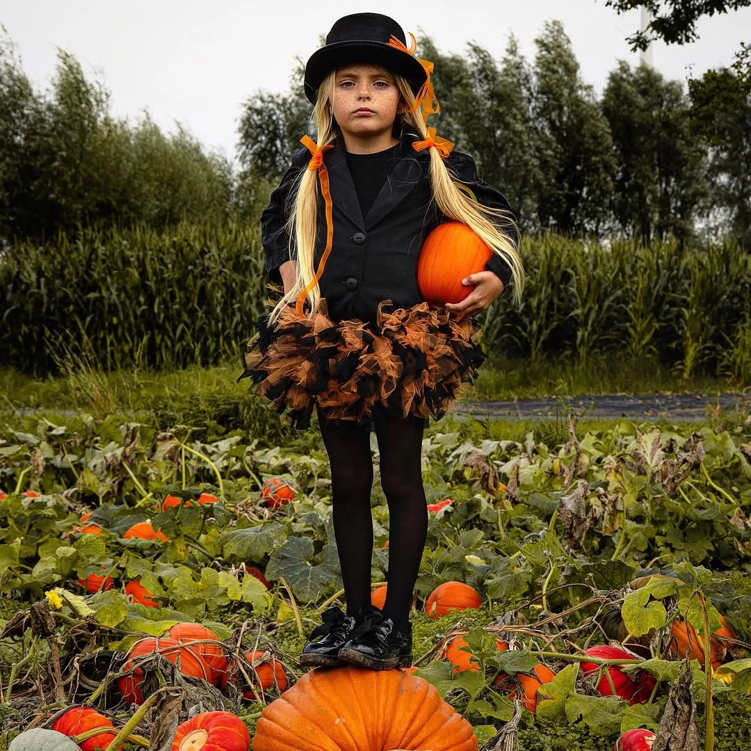 black outfit with dark fitted base with short textured skirt and hat