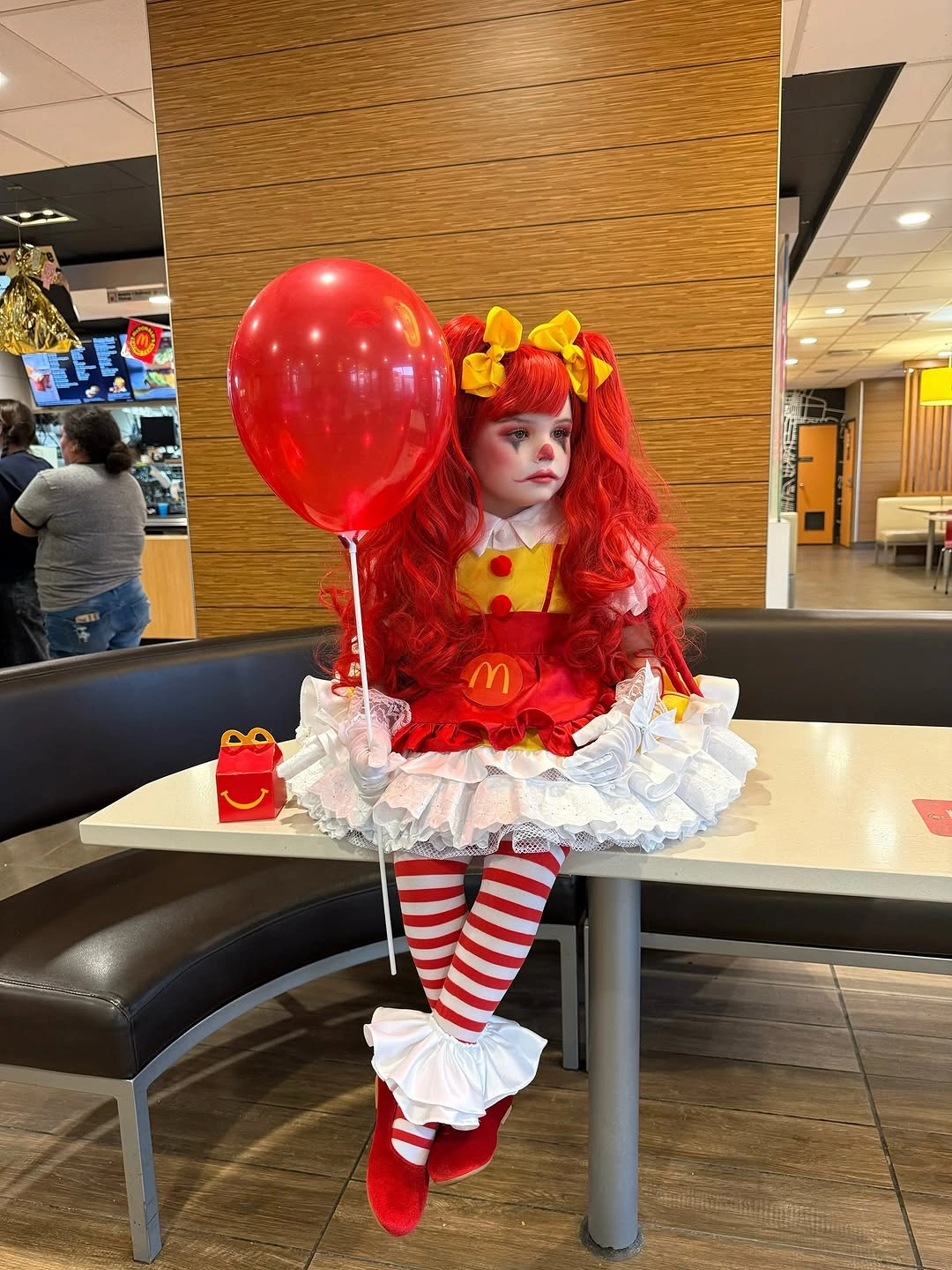 red outfit with rounded ruffled dress with striped tights and large hair bows