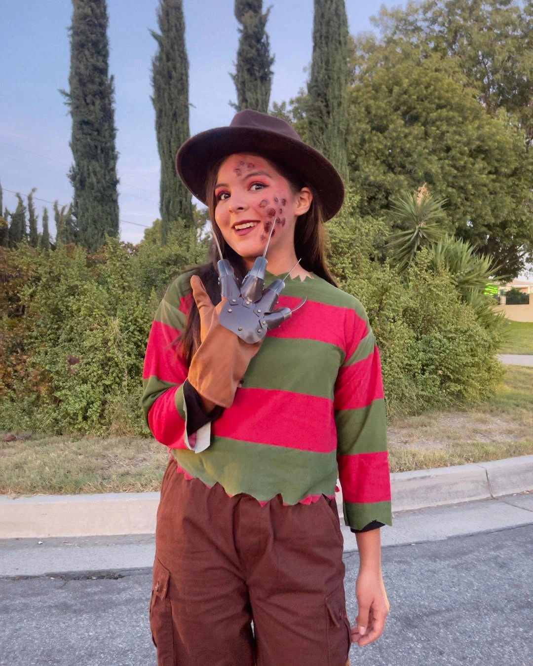 brown outfit with relaxed trousers with striped top and wide hat