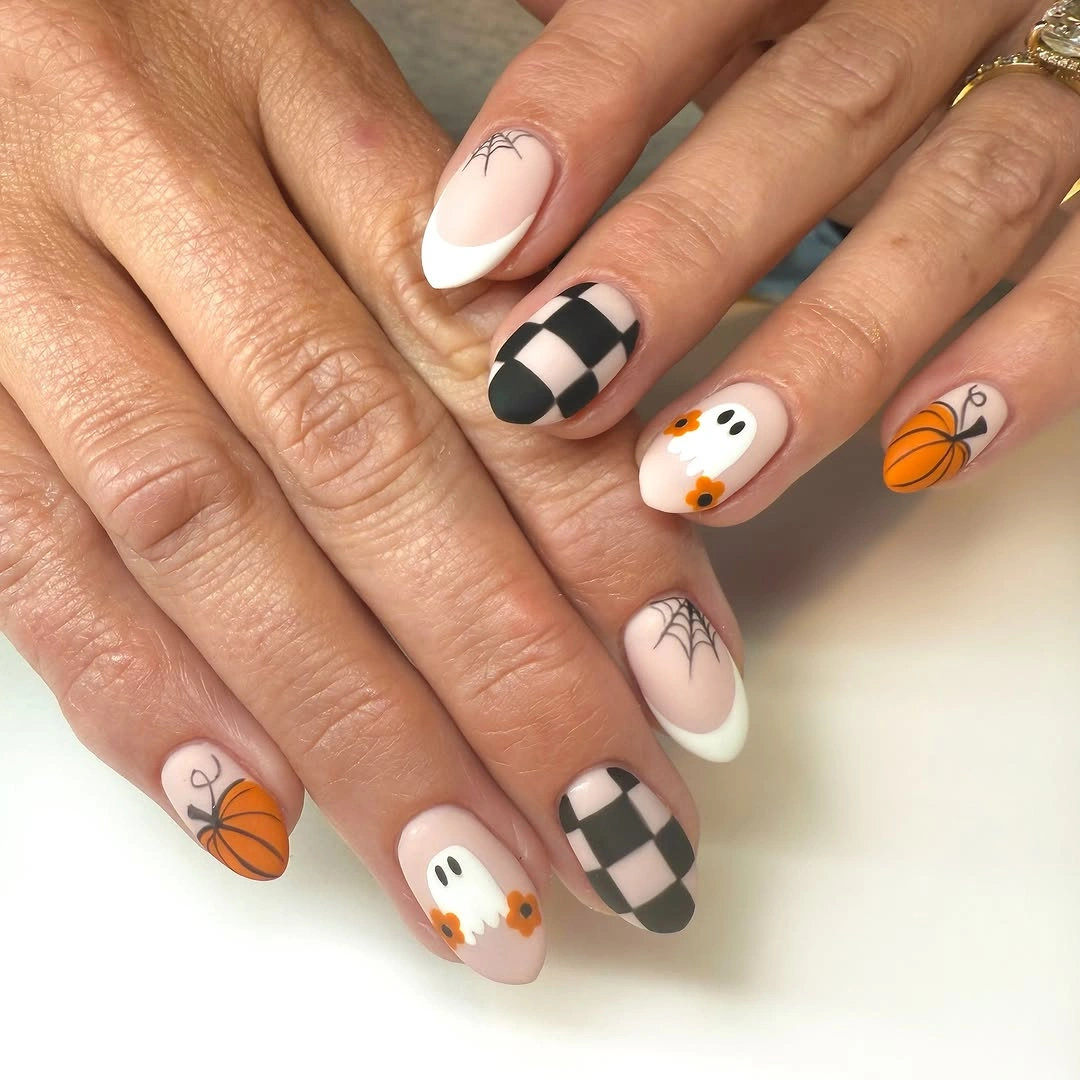 Medium oval pale nails with checkerboard pumpkins and ghosts