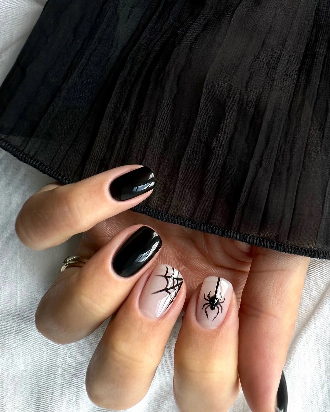 Medium almond glossy black nails with pale spiderweb accents