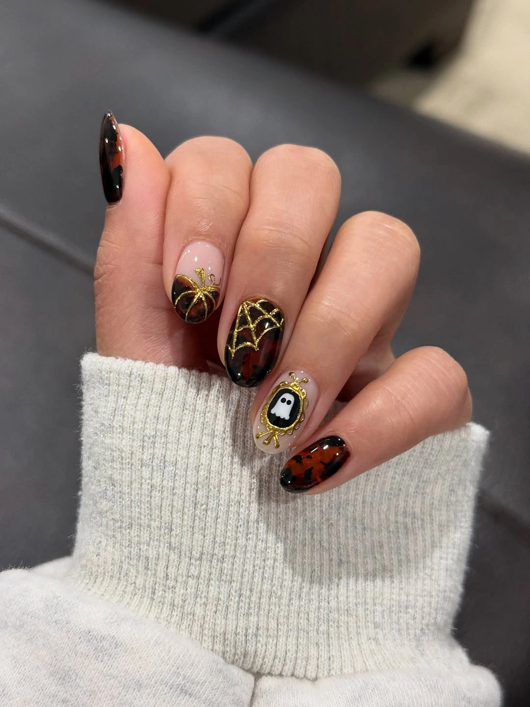 Medium almond sheer blush nails with dark amber symbols