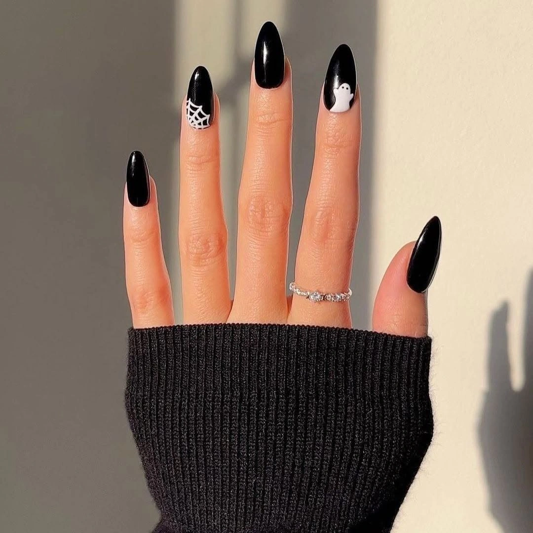Long stiletto black nails with white webs and ghosts