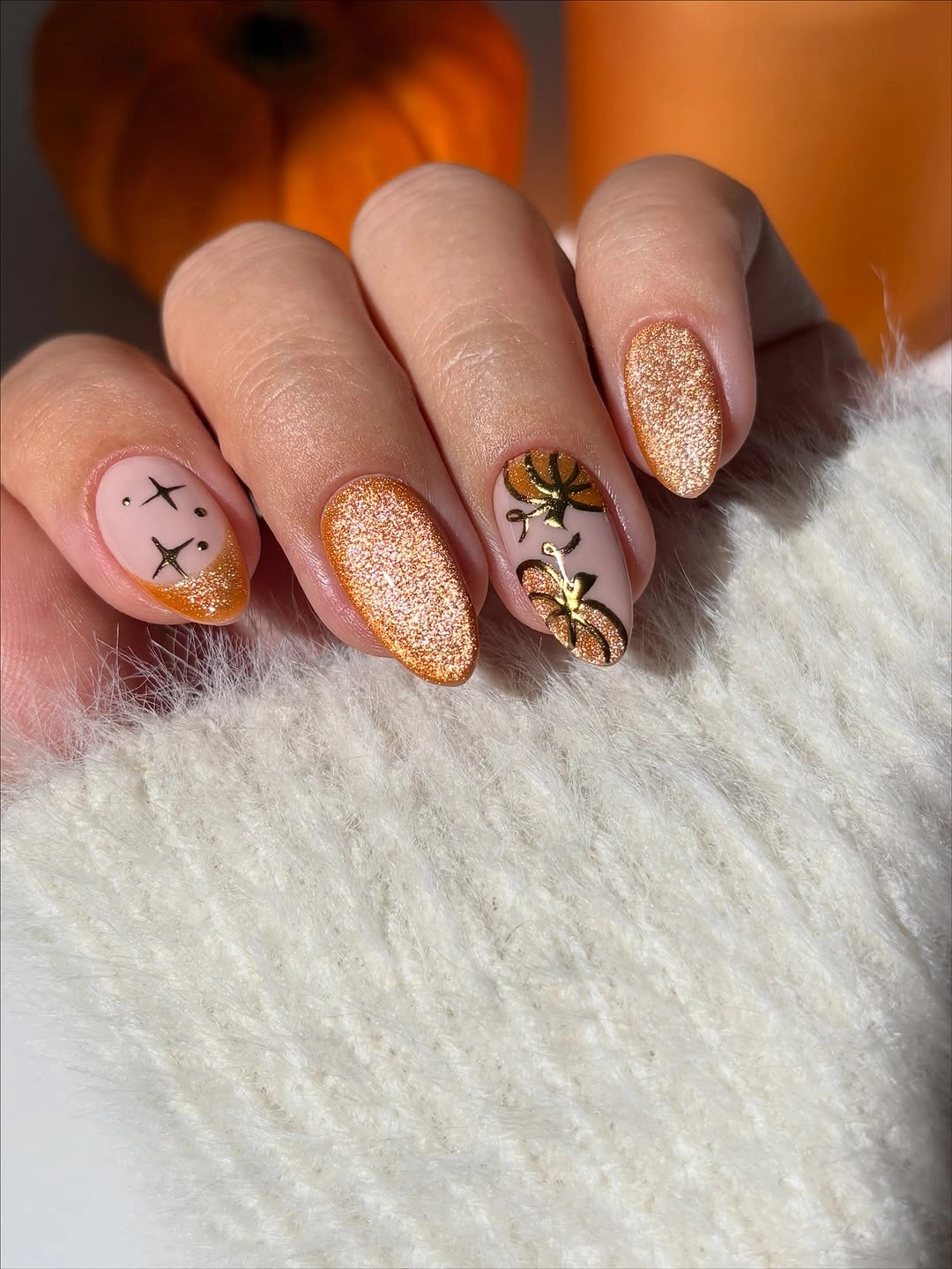 Short oval pale peach nails with glitter and spooky marks