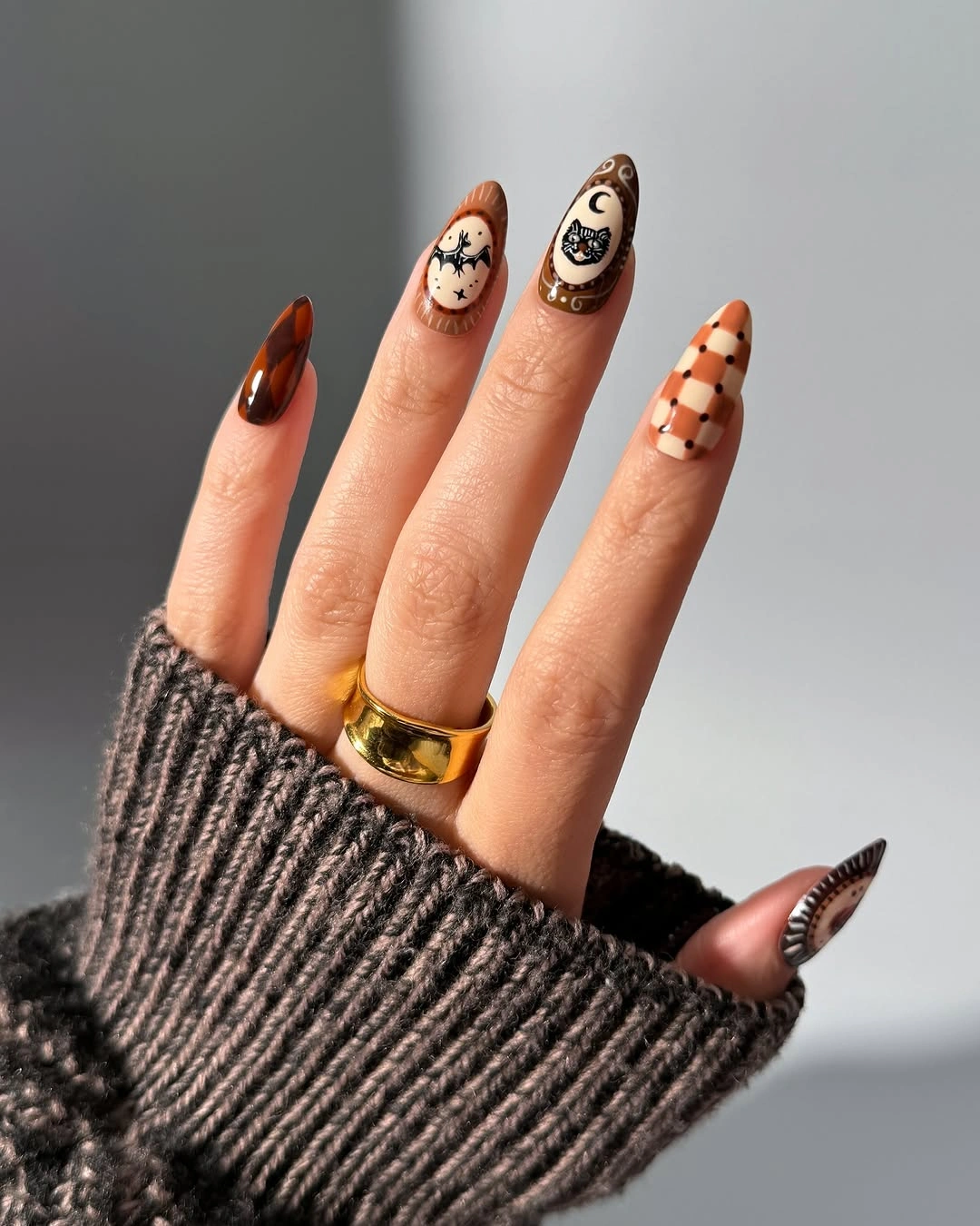 Long almond brown cream nails with ghosts and checkerboard