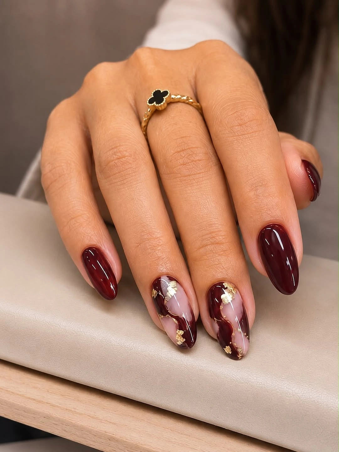 Glossy wine nails with pale marbled gold-flecked accents