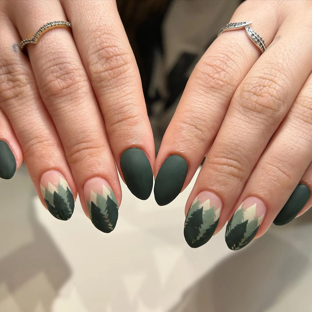 Short oval nails with bold green leaf silhouettes