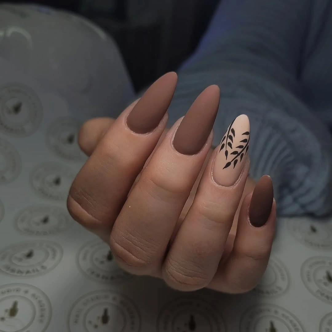Cocoa almond nails with one sparse black botanical accent