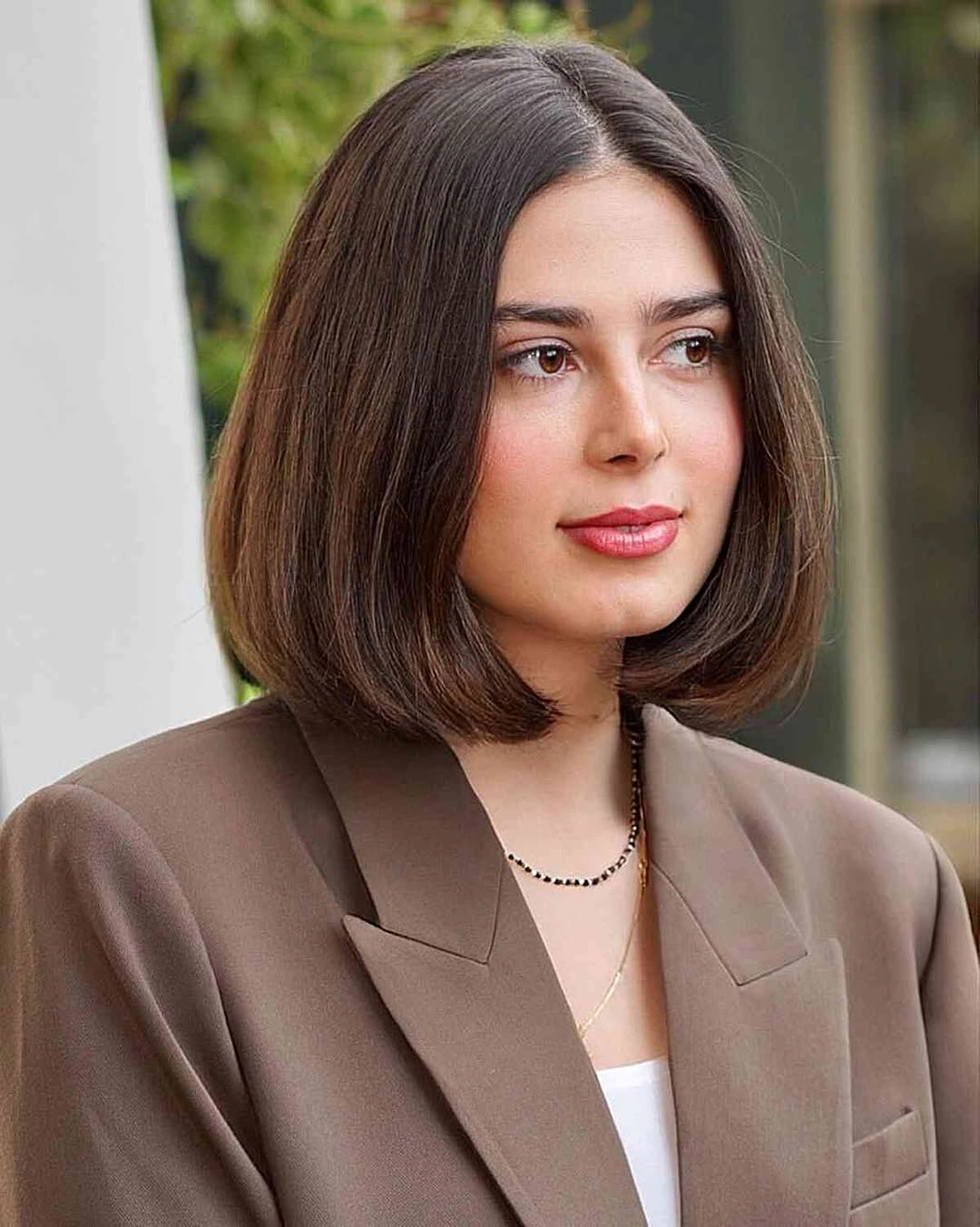 sleek brown bob with a precise center part
