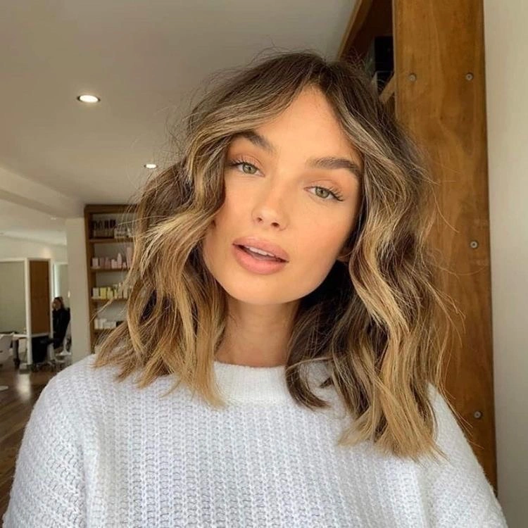 warm blonde shoulder-length waves with a middle part