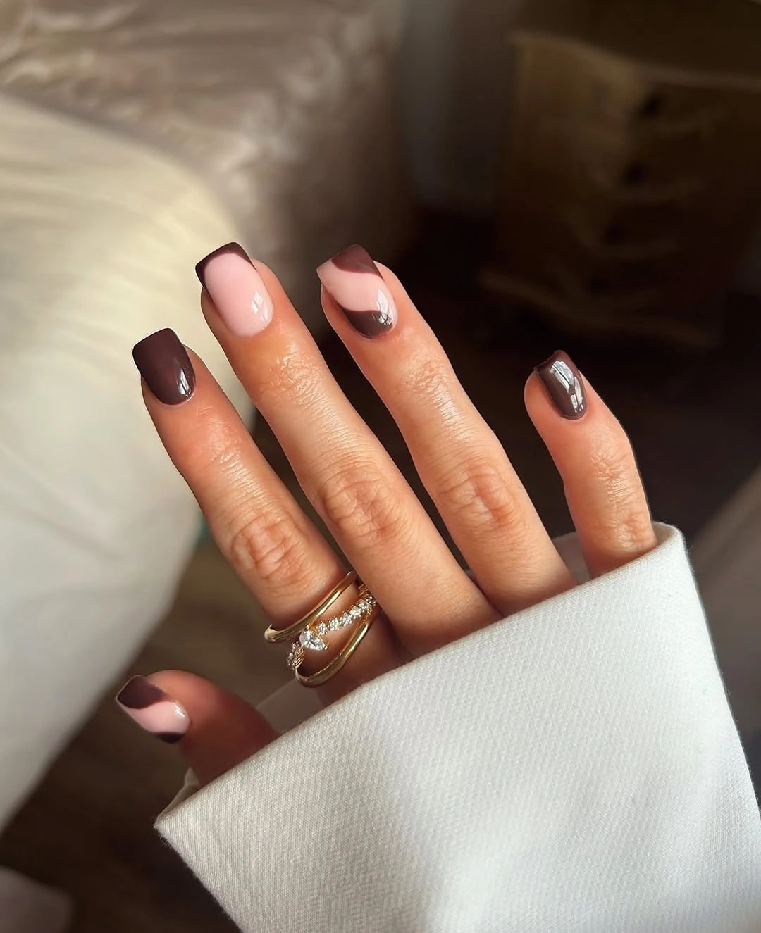 Medium almond nude nails with brown tips and glitter accents