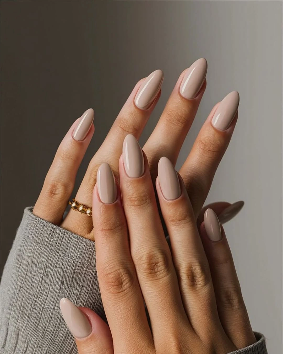 Long almond nails in uniform glossy greige nude