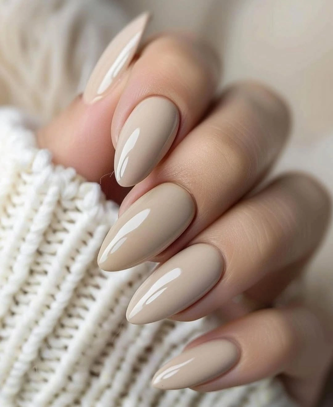 Long almond nails in glossy pale taupe nude