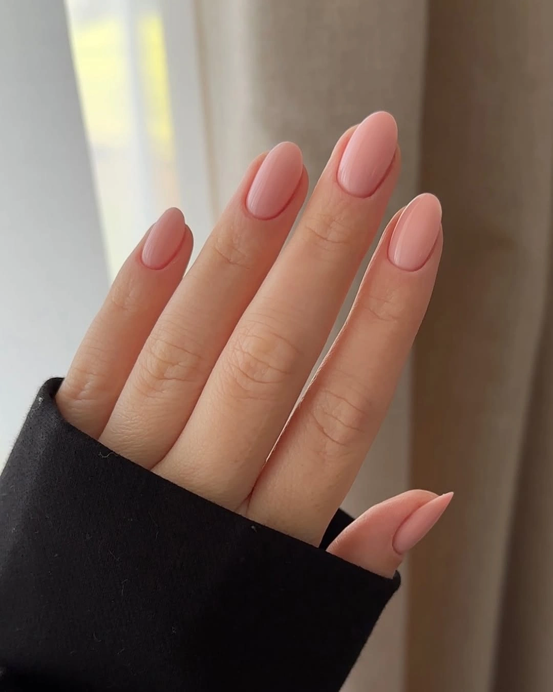 Long almond nails in uniform glossy blush nude