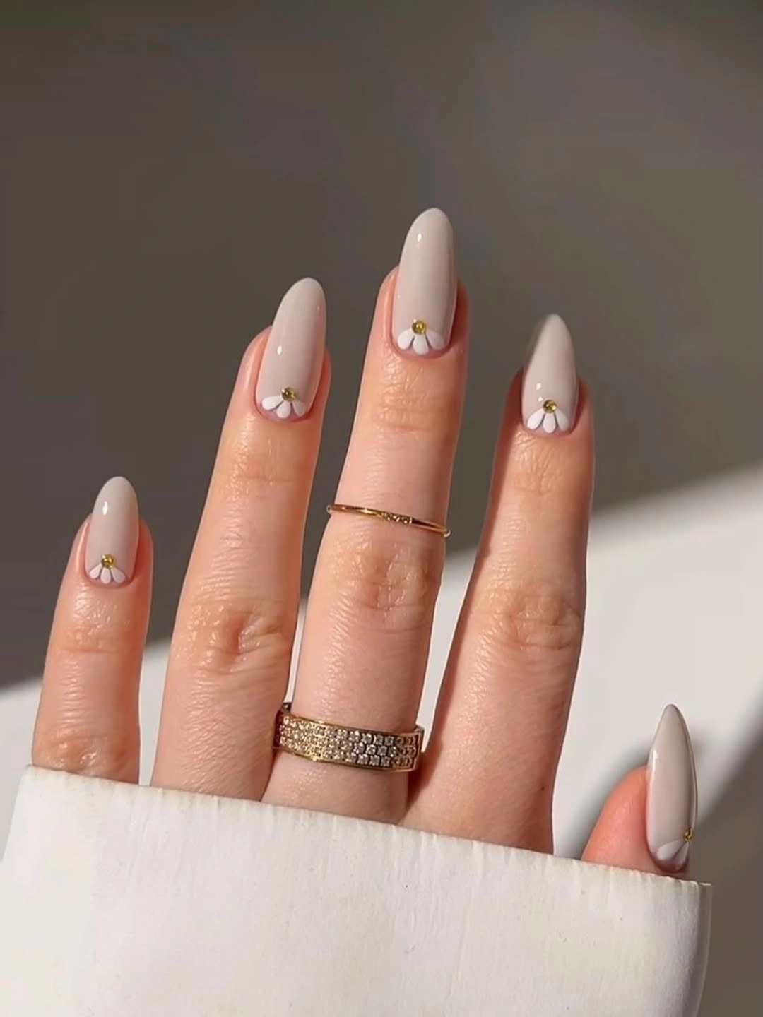 Long almond pale nude nails with tiny warm floral tips
