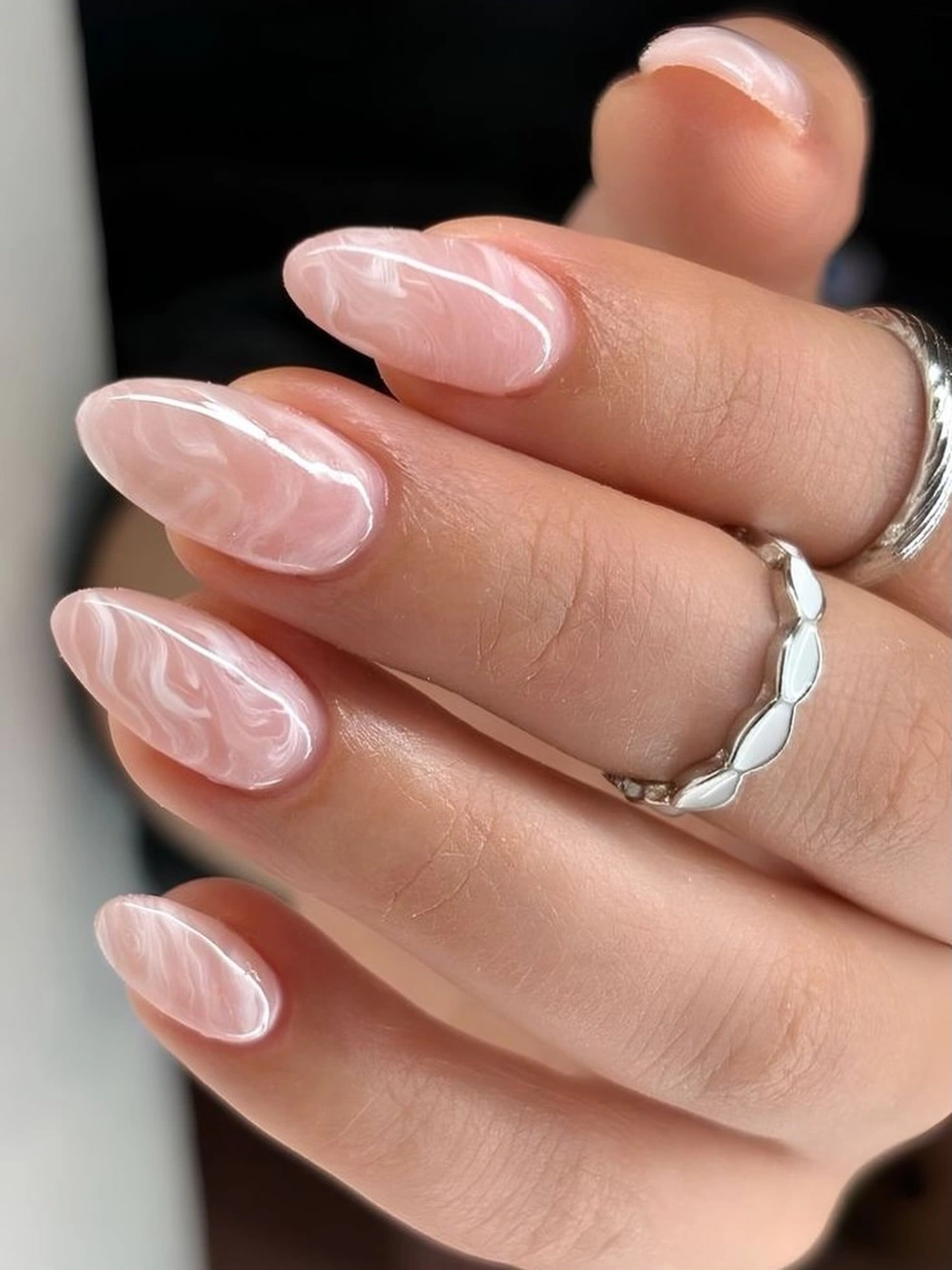 Long almond translucent pink nails with white swirl lines