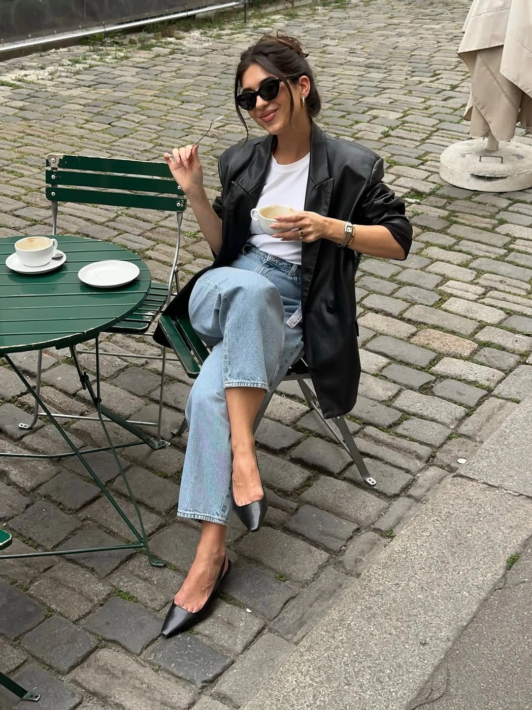 black outfit with relaxed jacket over straight jeans with pointed footwear