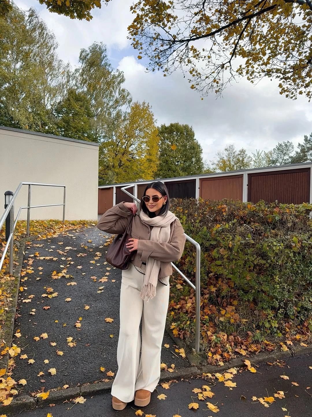cream outfit with soft scarf and short outer layer over wide-leg trousers