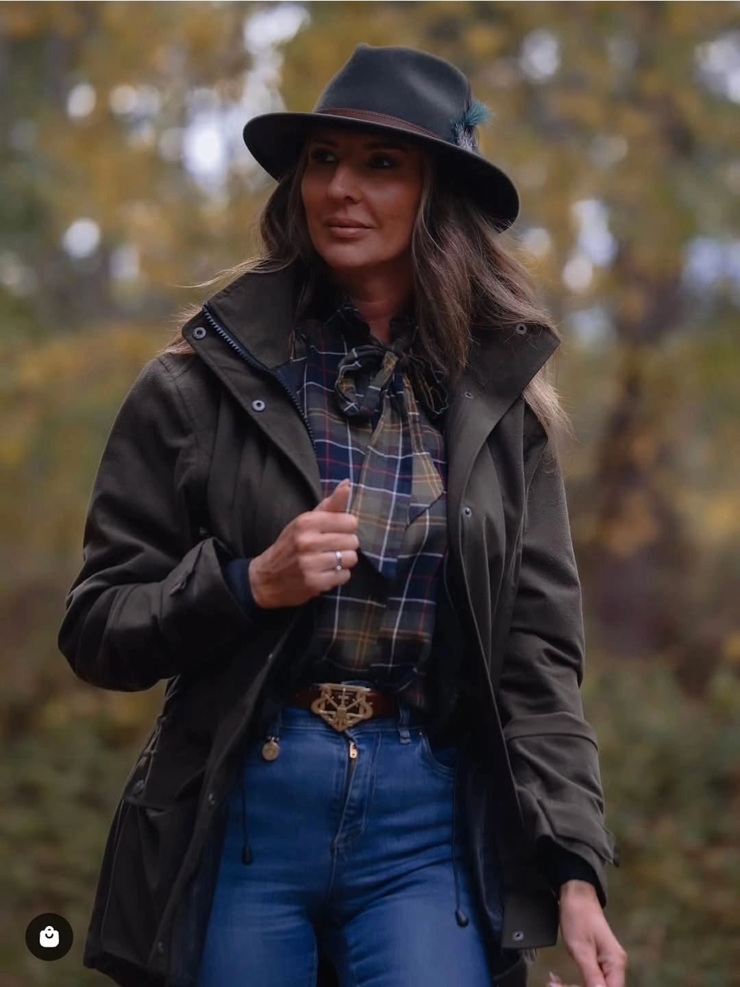 black outfit with structured jacket over tucked plaid shirt and straight jeans