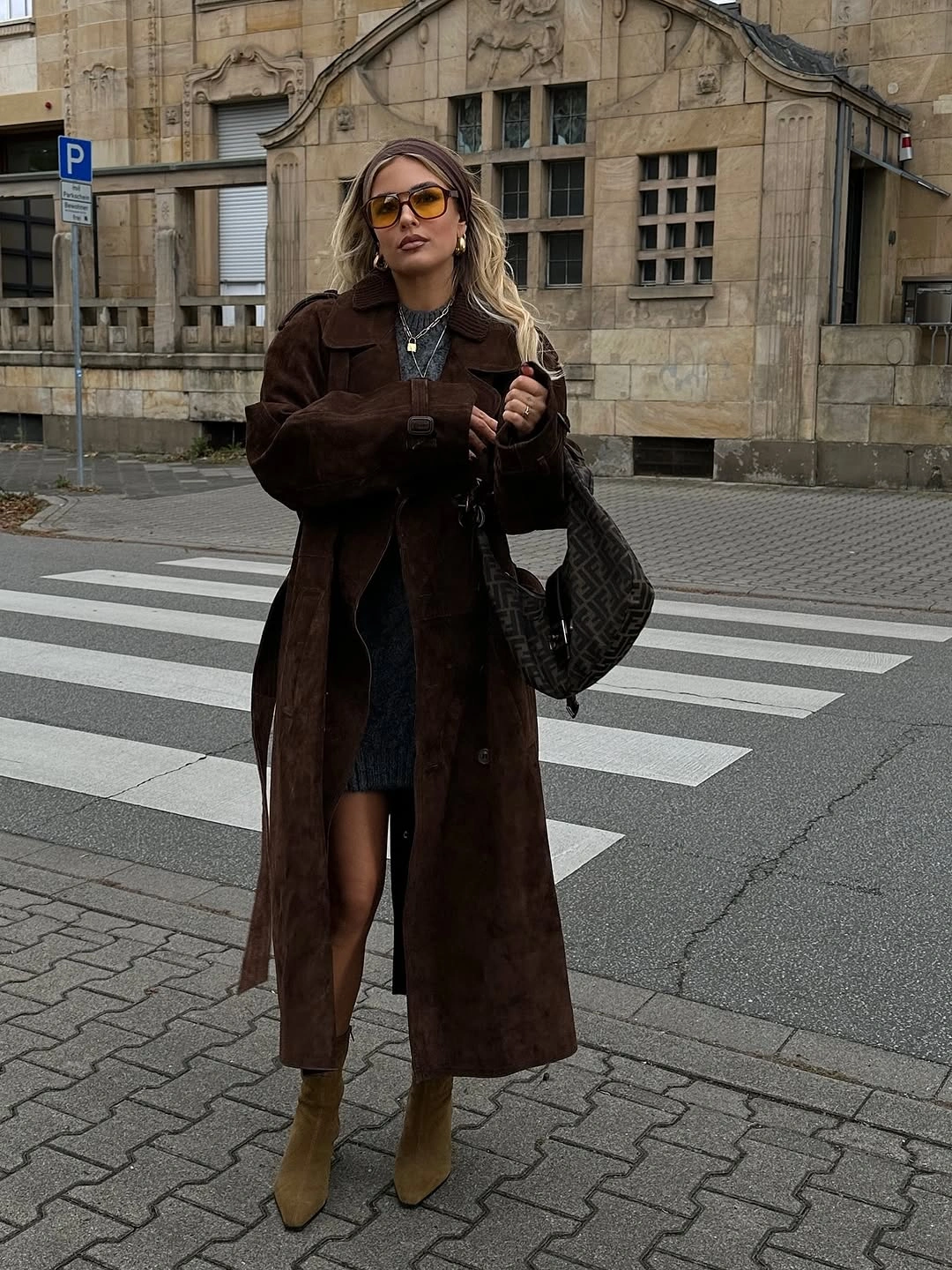 dark brown outfit with long belted coat over short dark dress with ankle boots