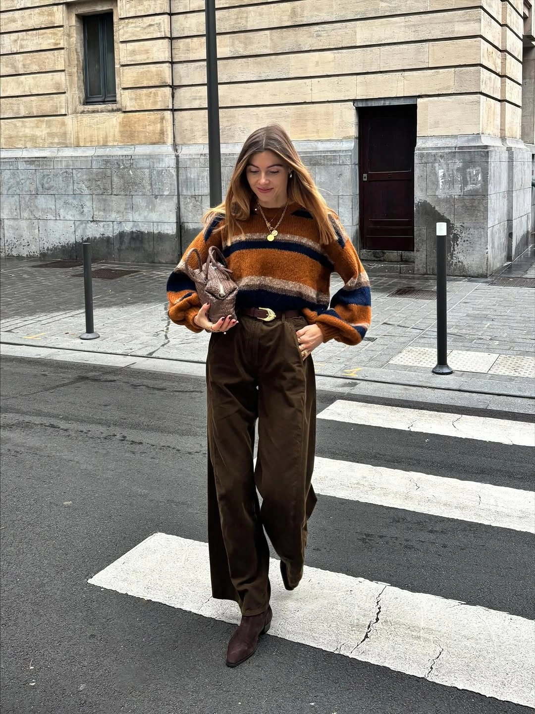 rust outfit with relaxed striped sweater over high-waisted trousers