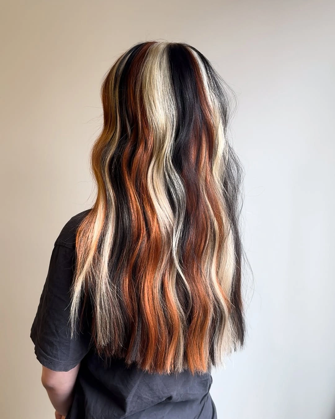 dark brown long layered waves with blonde and copper ribbons