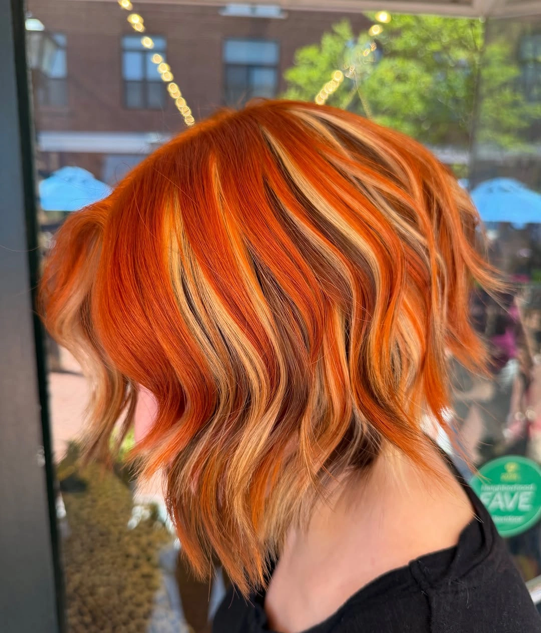 copper orange short wavy bob with blonde highlight ribbons