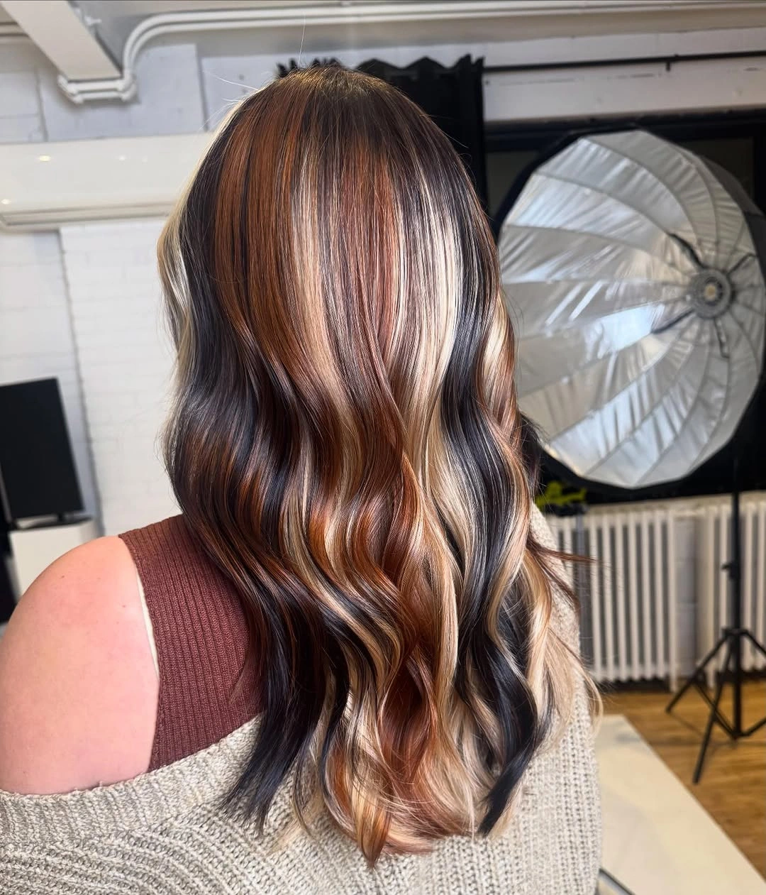 dark brown long layered waves with blonde and copper ribbons