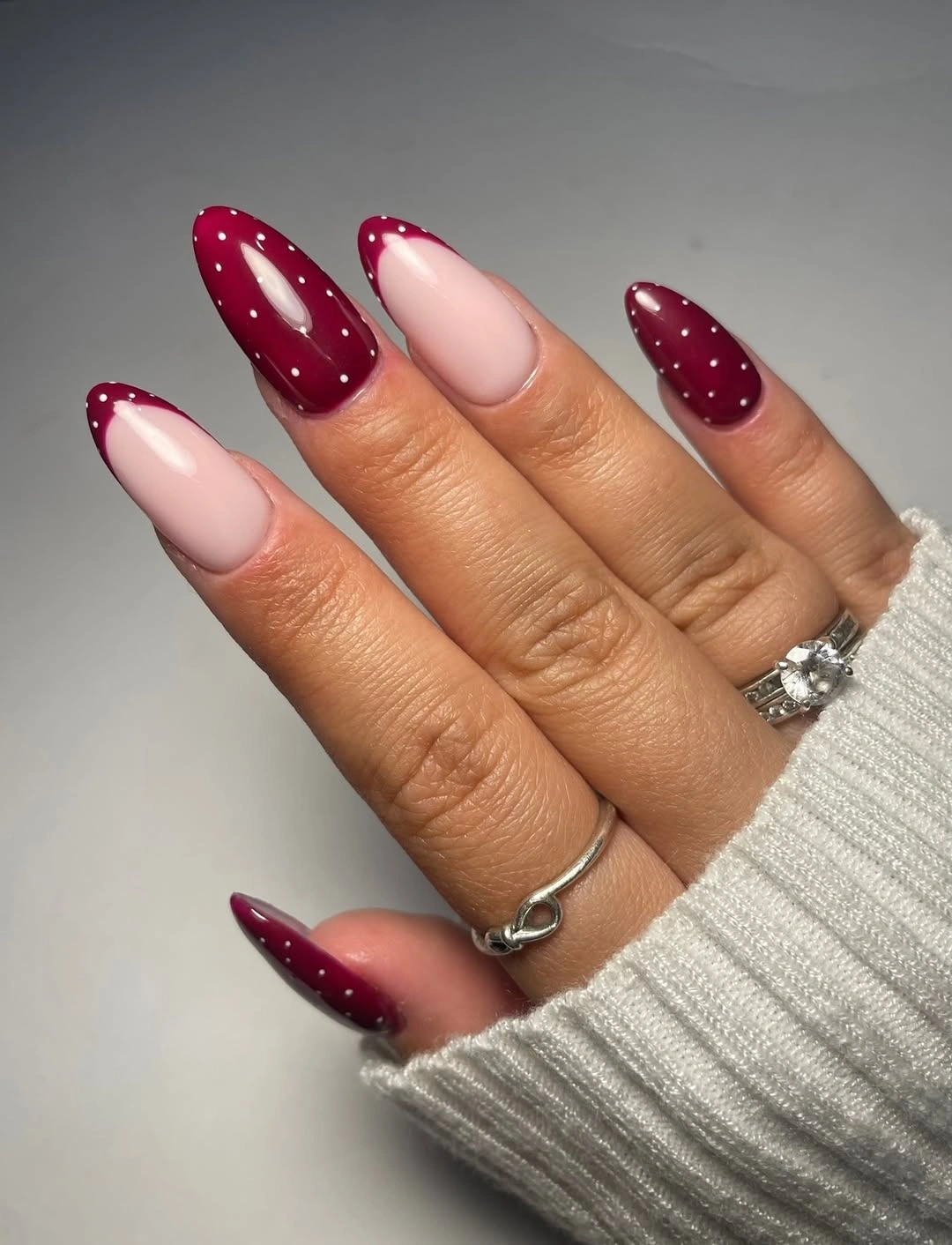 pale pink long almond nails with burgundy tips and dots