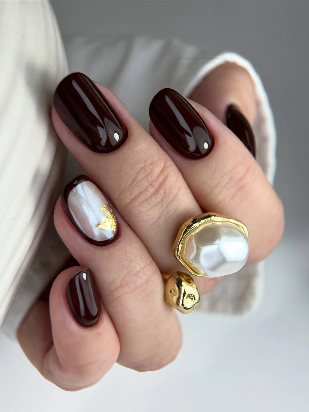 dark chocolate brown medium oval nails with gold accent on pale base