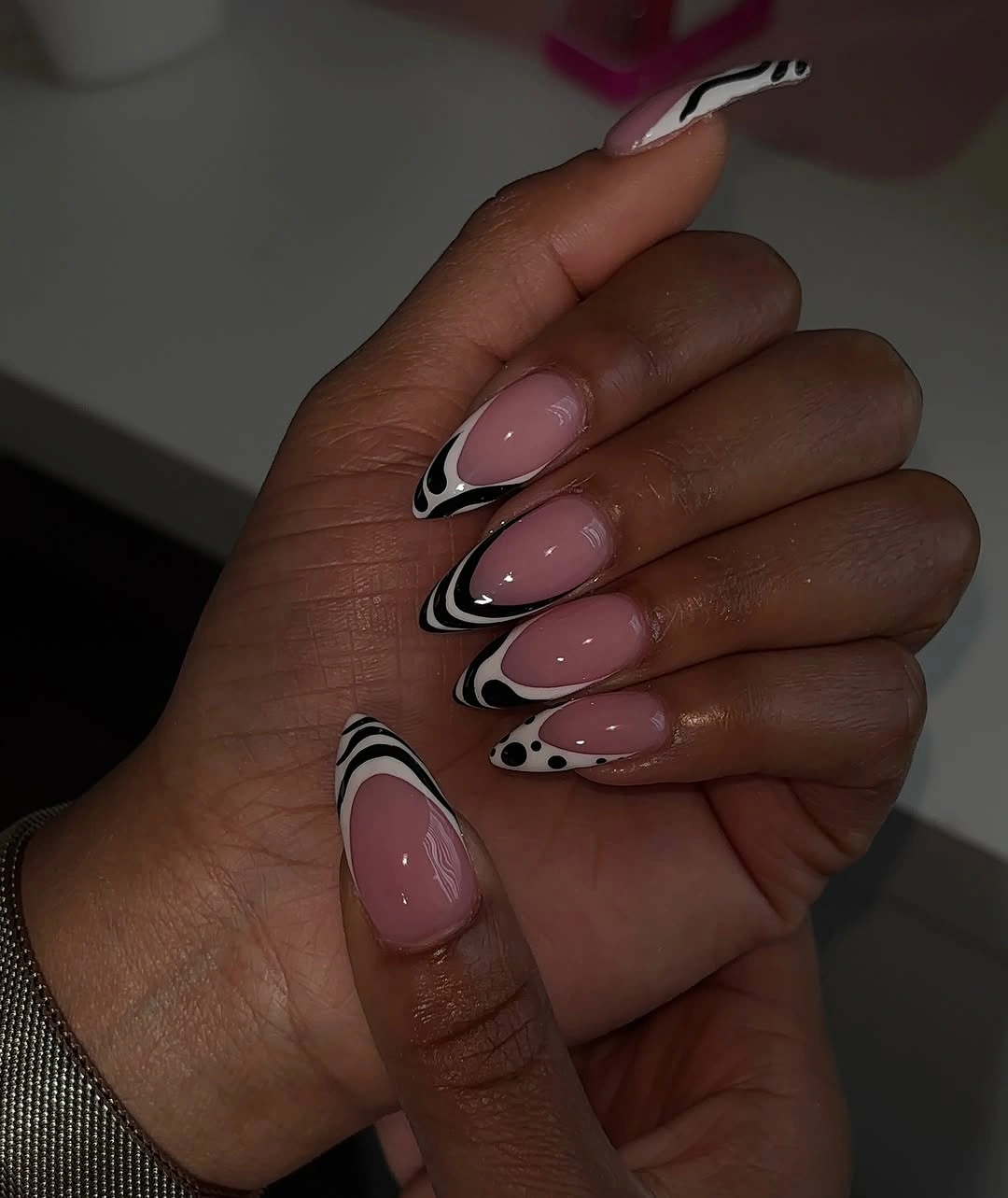 pale pink long almond nails with black-and-white wave tips
