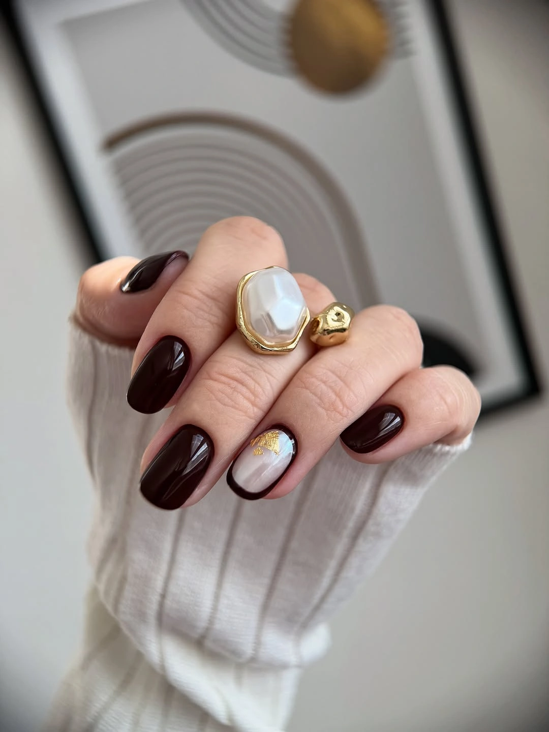 dark brown medium oval nails with small gold-orange line