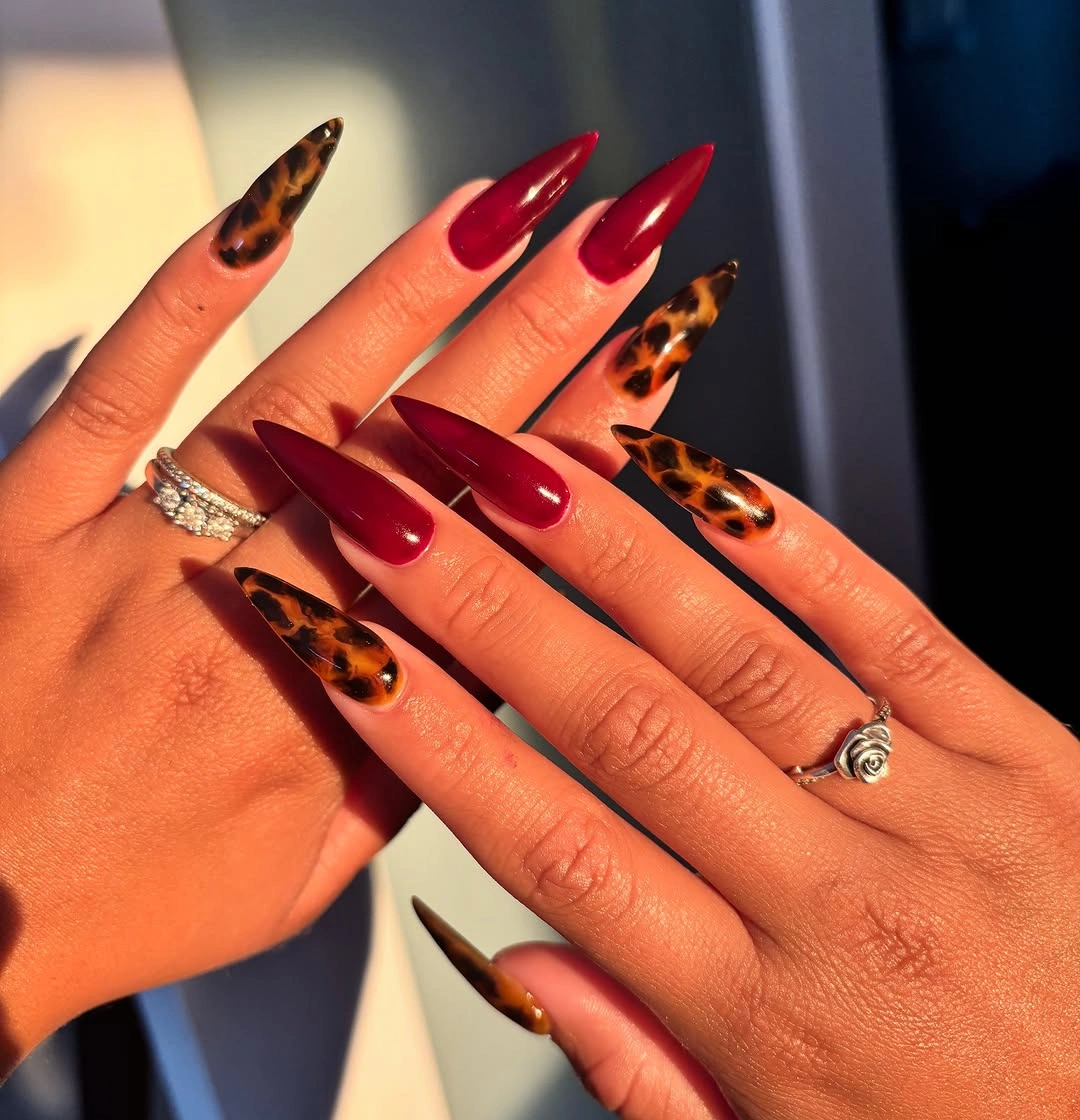 burgundy long pointed almond nails with leopard pattern