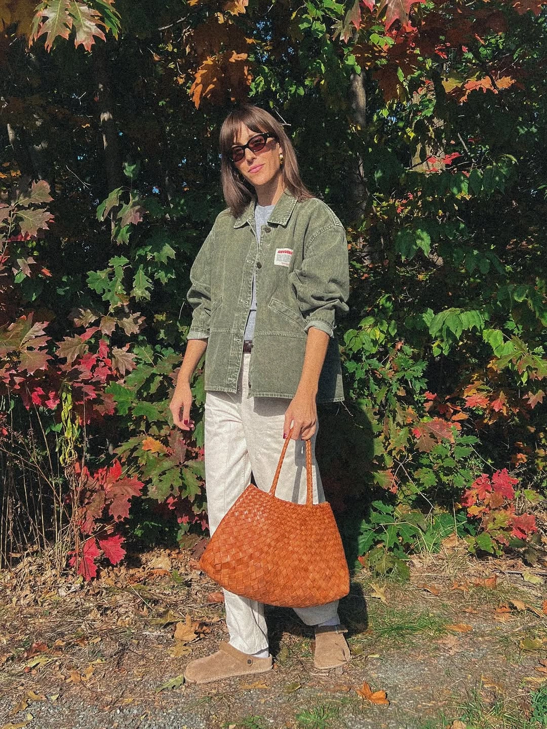 sage green outfit with short utility layer over wide pale trousers