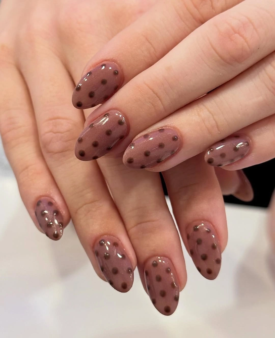 Mauve brown almond nails with evenly spaced dark dots