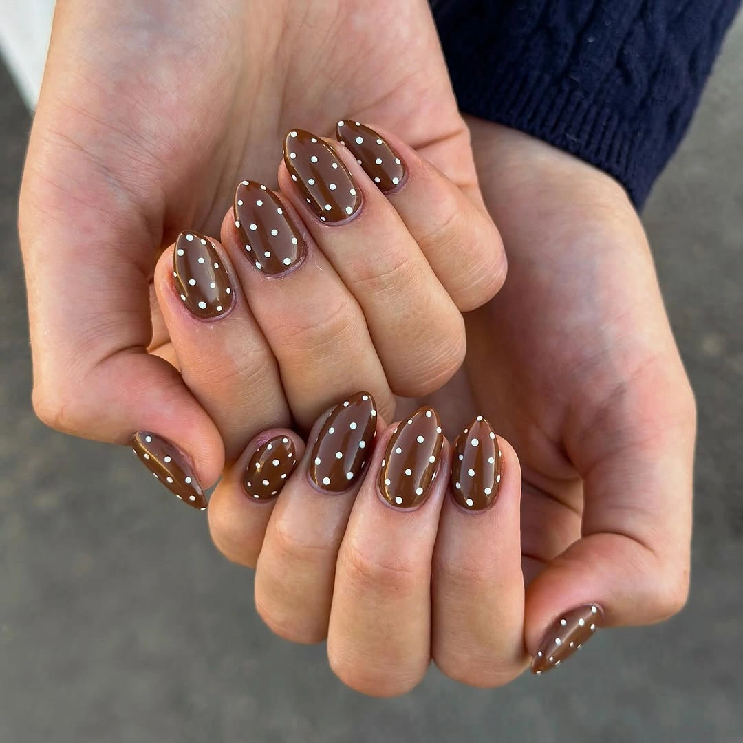 Warm taupe oval nails with white dots and tiny warm accents