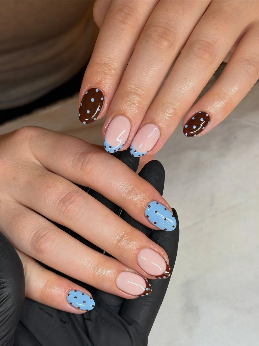 Pale blue and brown rounded nails with reversed dots