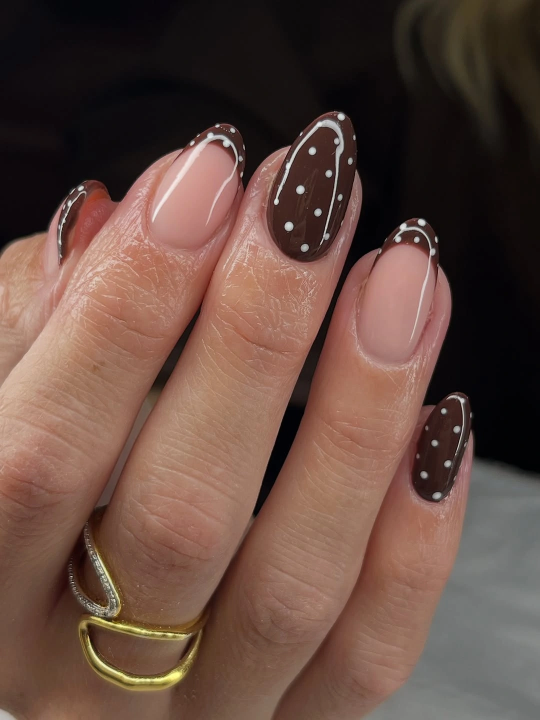 Nude almond nails with brown dotted accents and fine edges