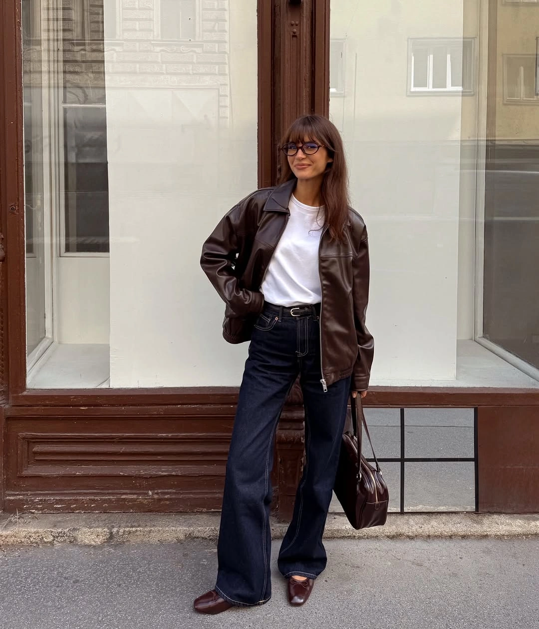 Brown jacket over white tee with wide dark jeans