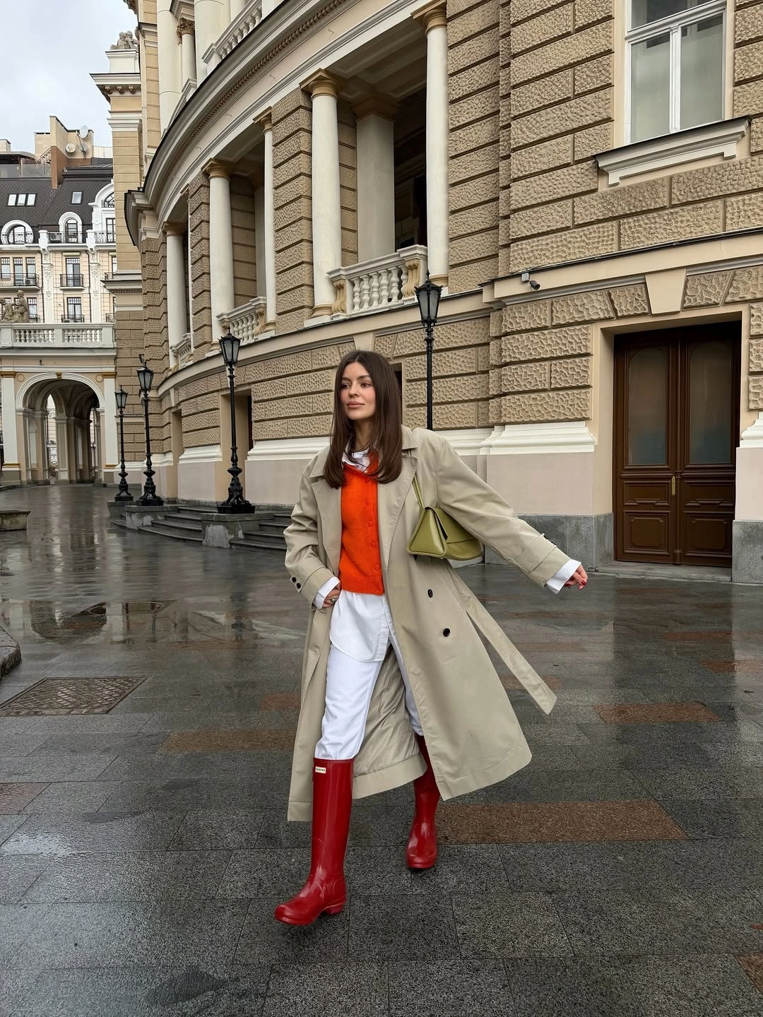 Beige coat with orange top white trousers and red boots