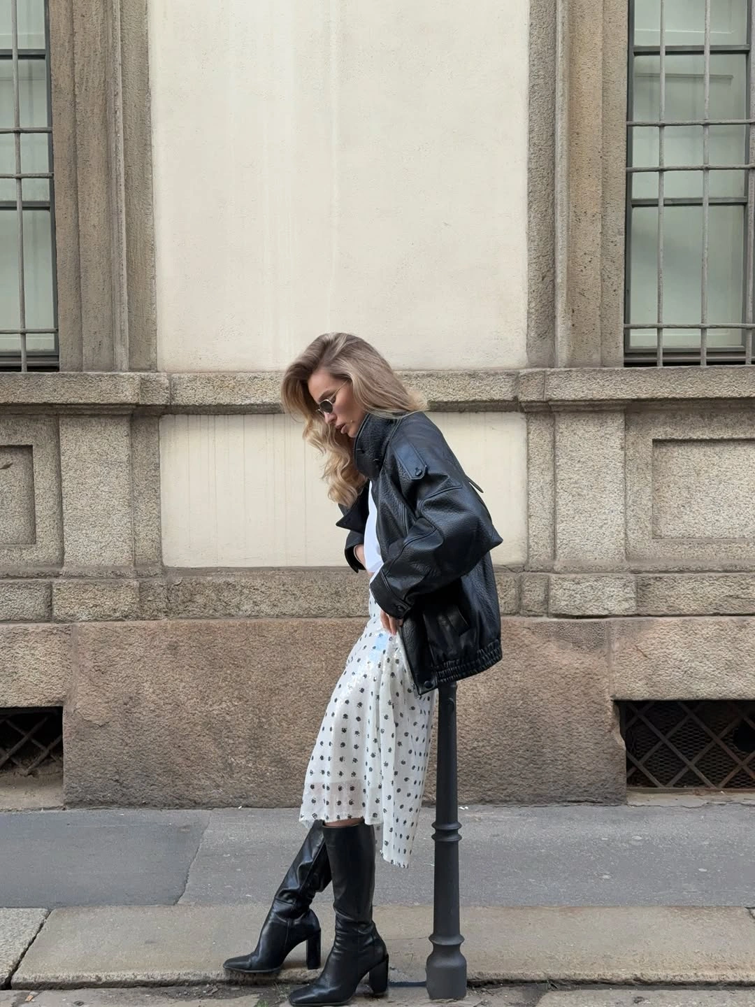 Dark jacket with polka dot skirt and tall boots
