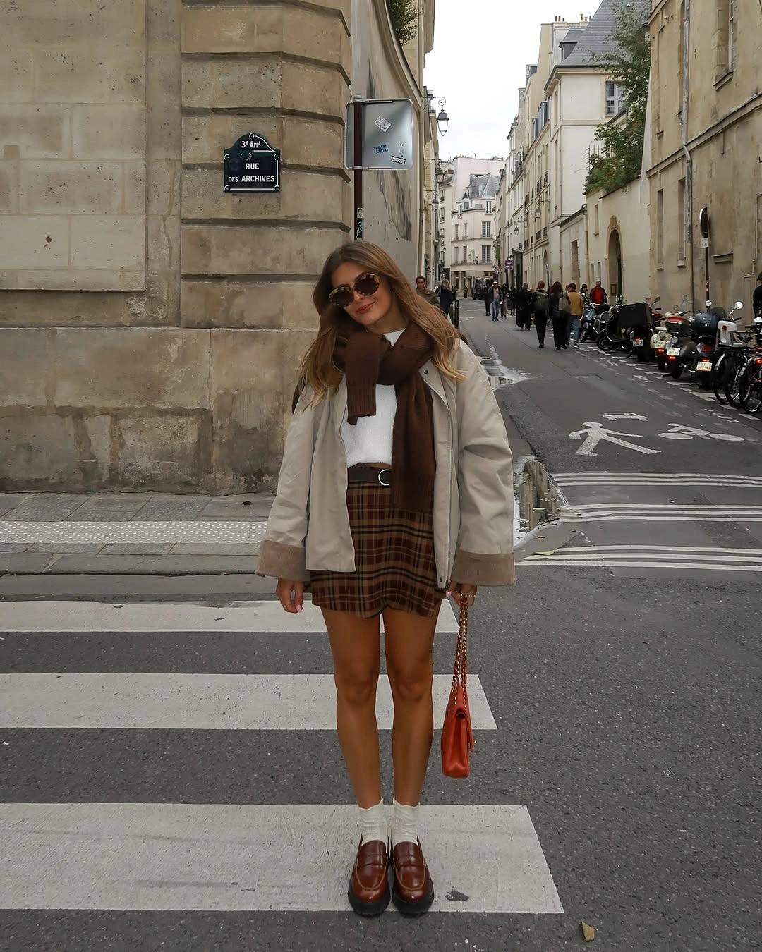 Light jacket with brown plaid mini skirt and orange bag