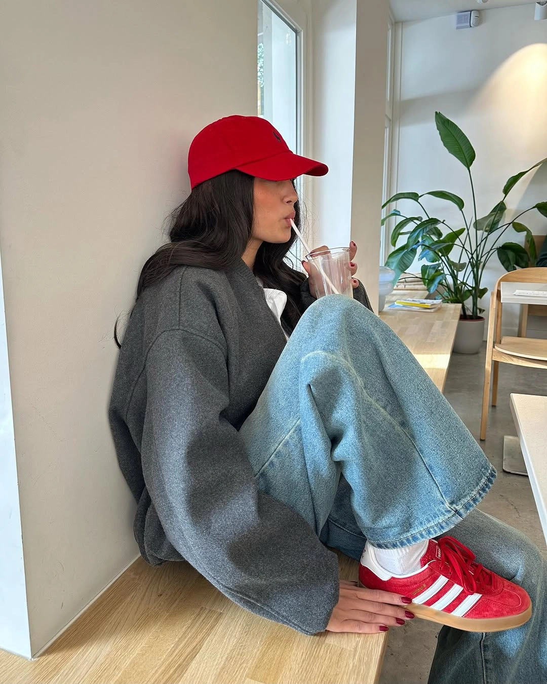 Oversized gray sweater with wide jeans and red sneakers