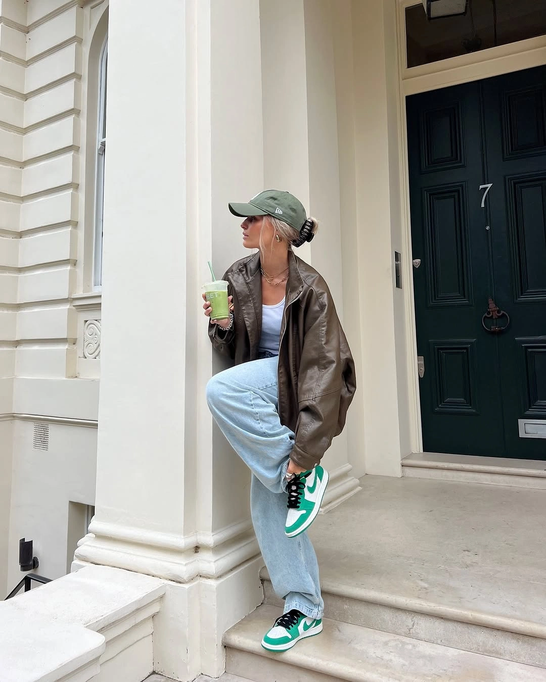 Brown jacket with blue jeans and green sneakers