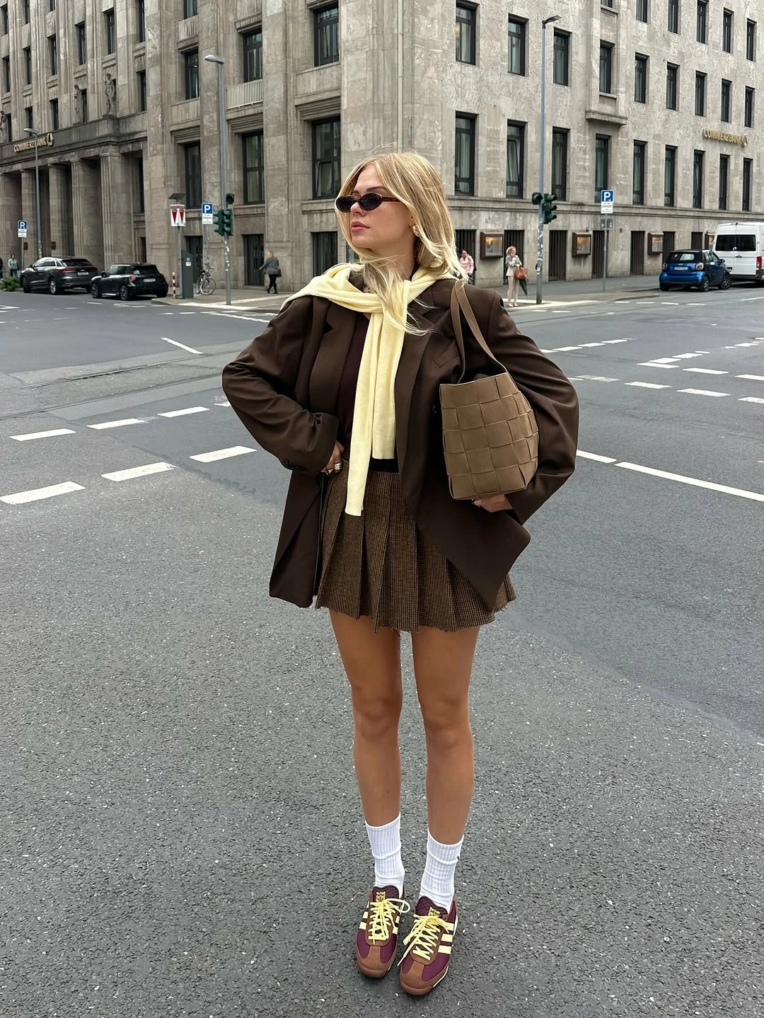 Brown pleated skirt with pale scarf and burgundy sneakers