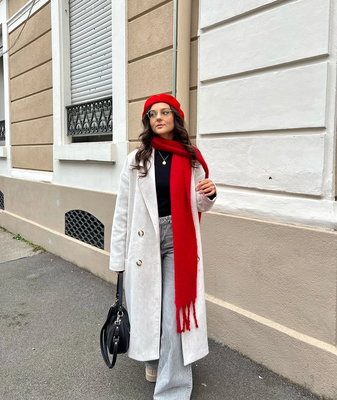 Neutral long coat with red hat scarf and pale trousers
