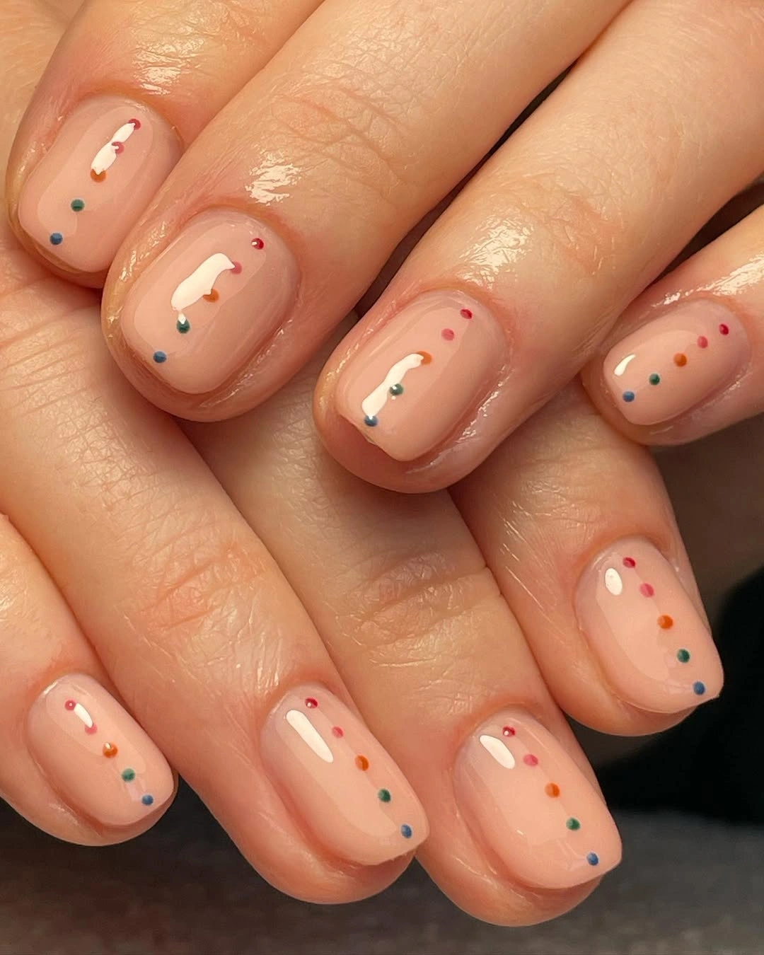 short rounded nude nails with tiny multicolor dots