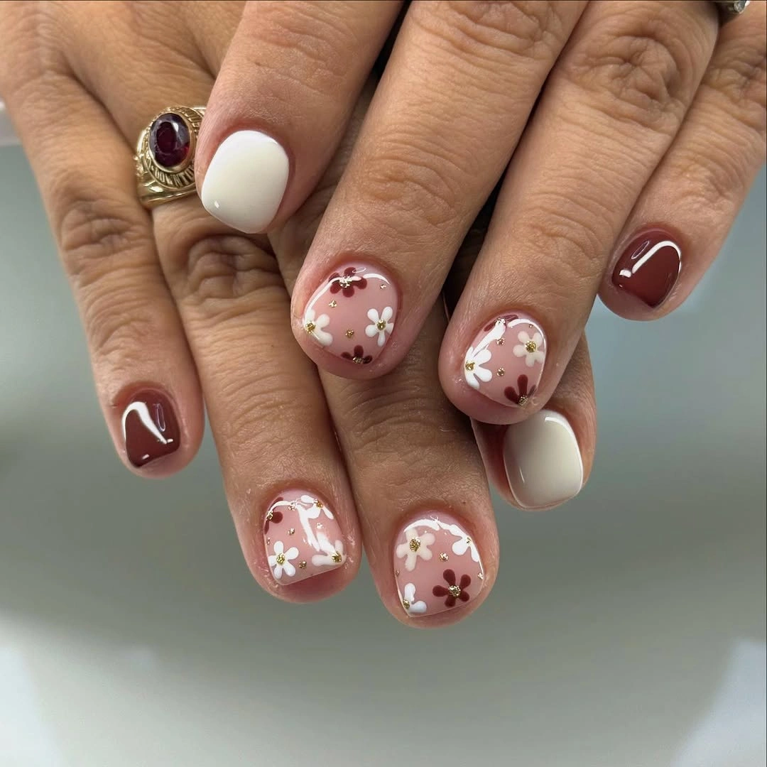 short rounded nude nails with small pale floral accents