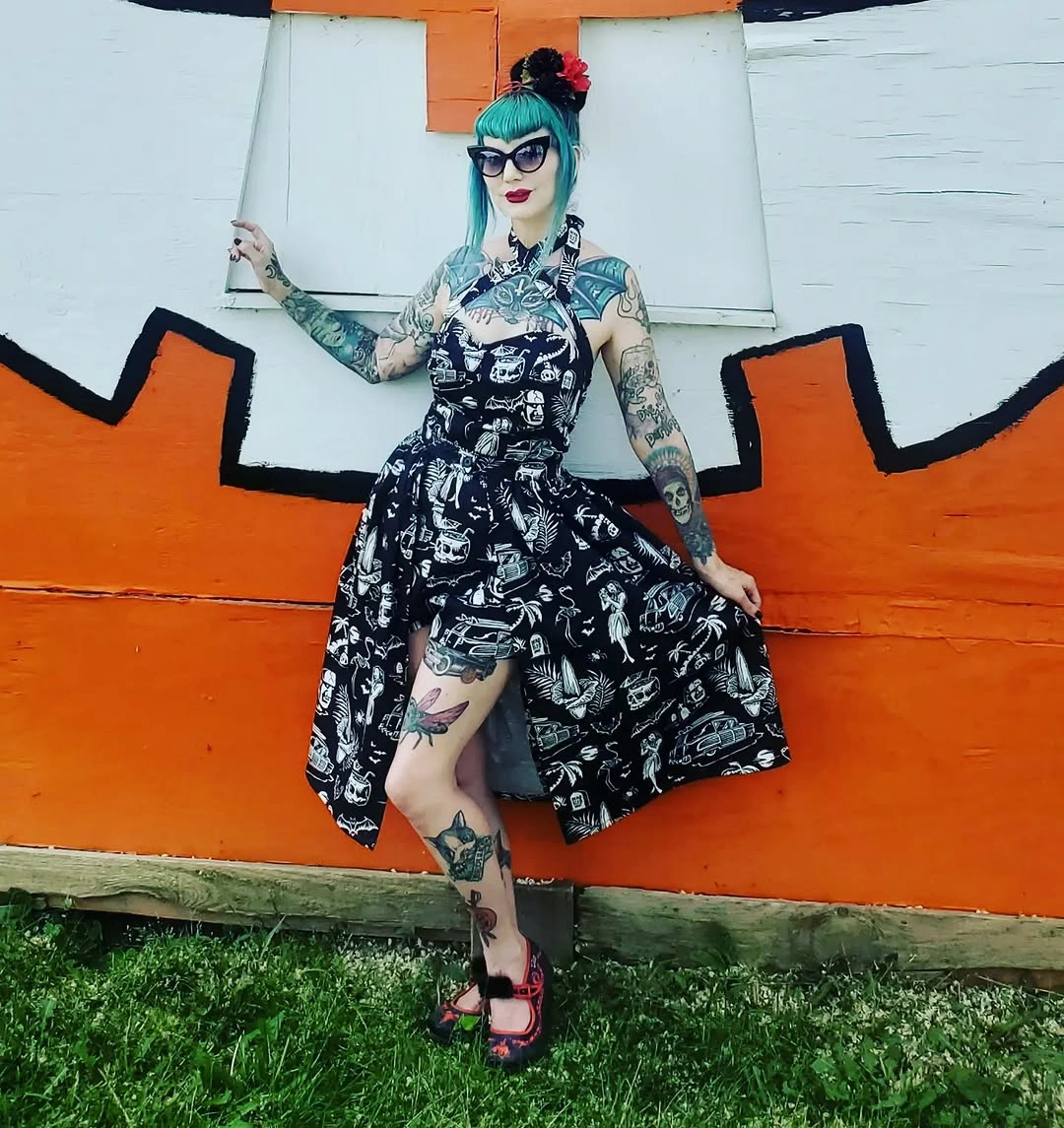 black outfit with fitted graphic dress with a flared skirt and open lower movement