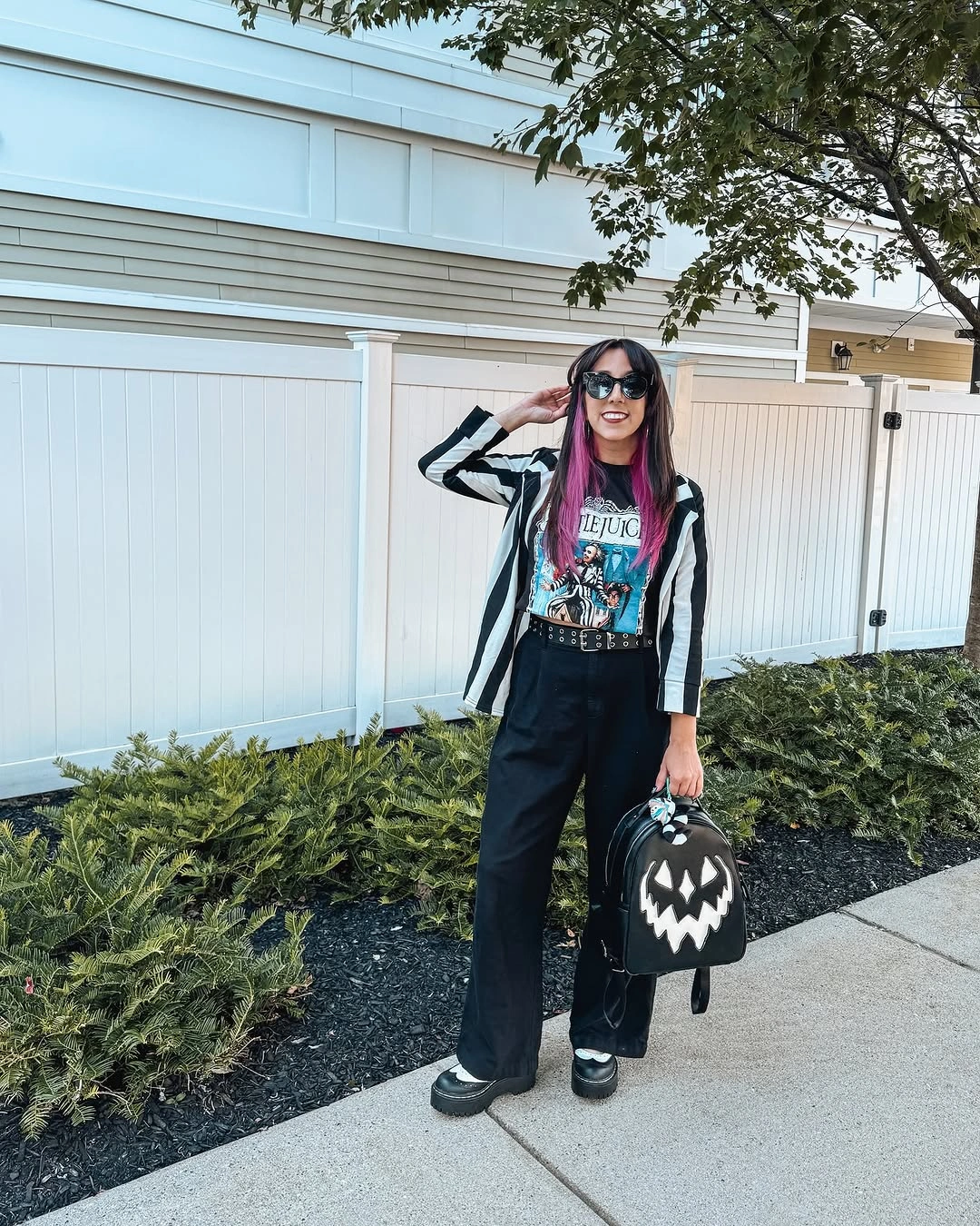 black outfit with long open striped layer over graphic tee and wide trousers